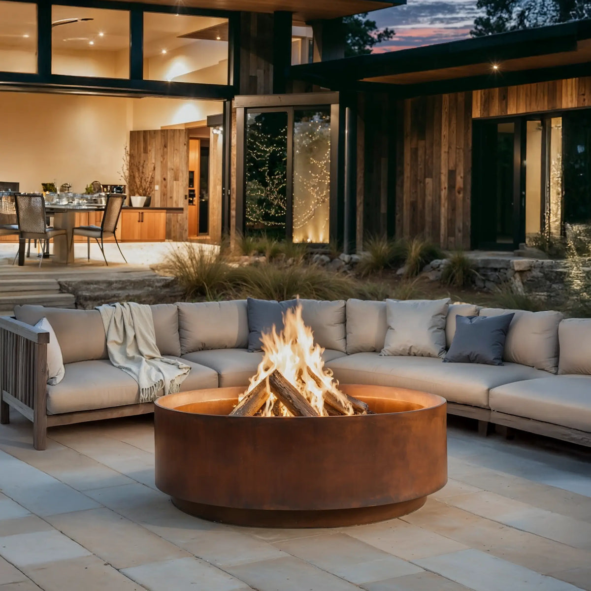 Outdoor patio with Jake fire pit, seating area, and modern house in the background