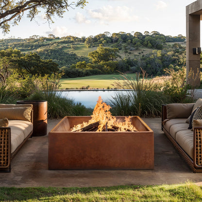 Outdoor patio with Jackson fire pit, couches, and scenic view of a lake and hills.